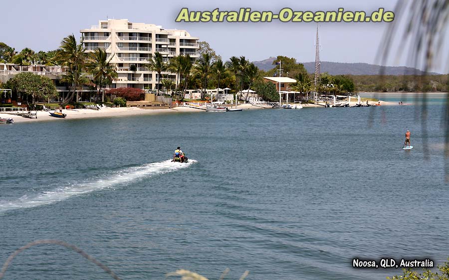 Appartements und Boote am Flußufer, Jetskifahrer